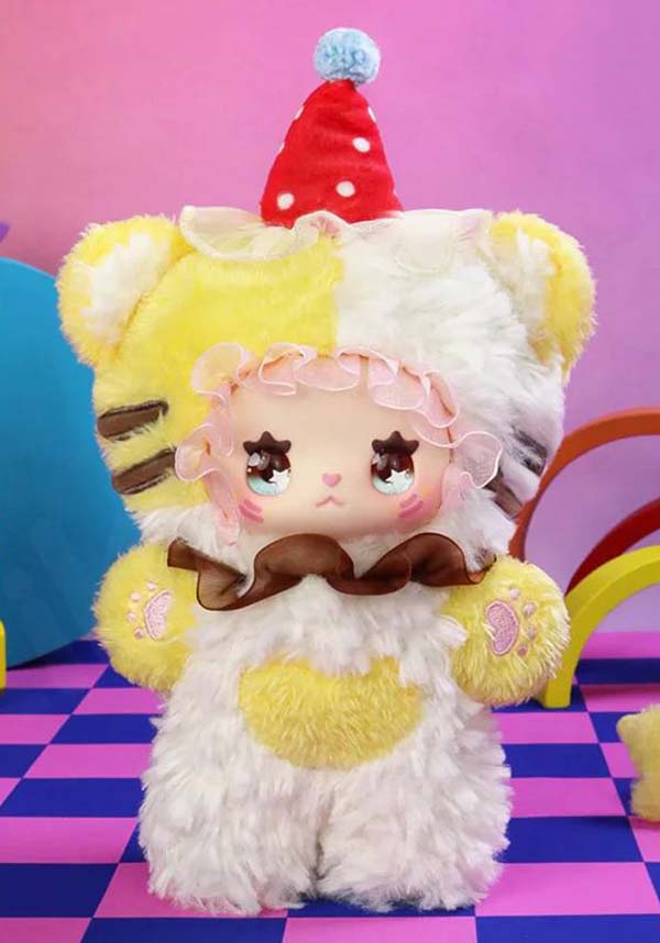 Cute plush toy with a yellow and white outfit on a colorful checkered floor.