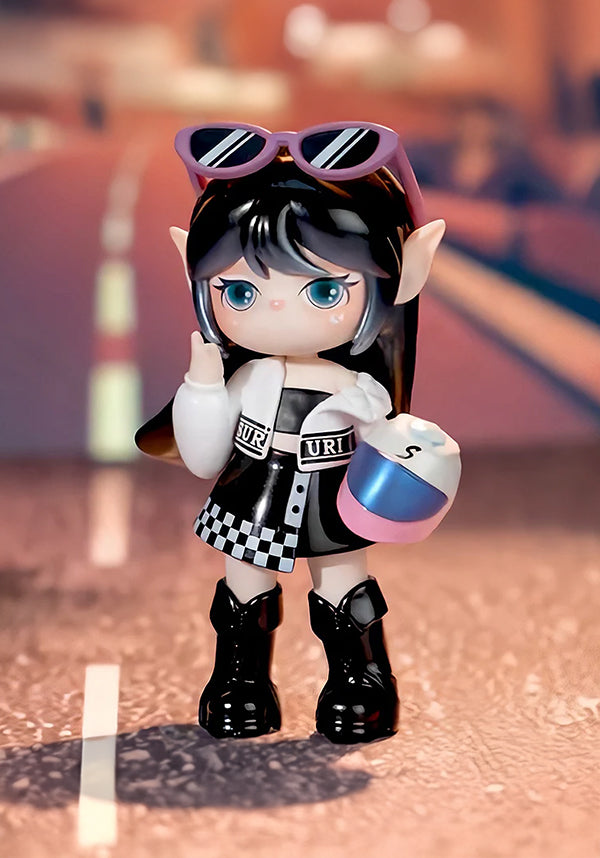 Toy figure with black hair, sunglasses, and checkered outfit standing on a reflective surface.