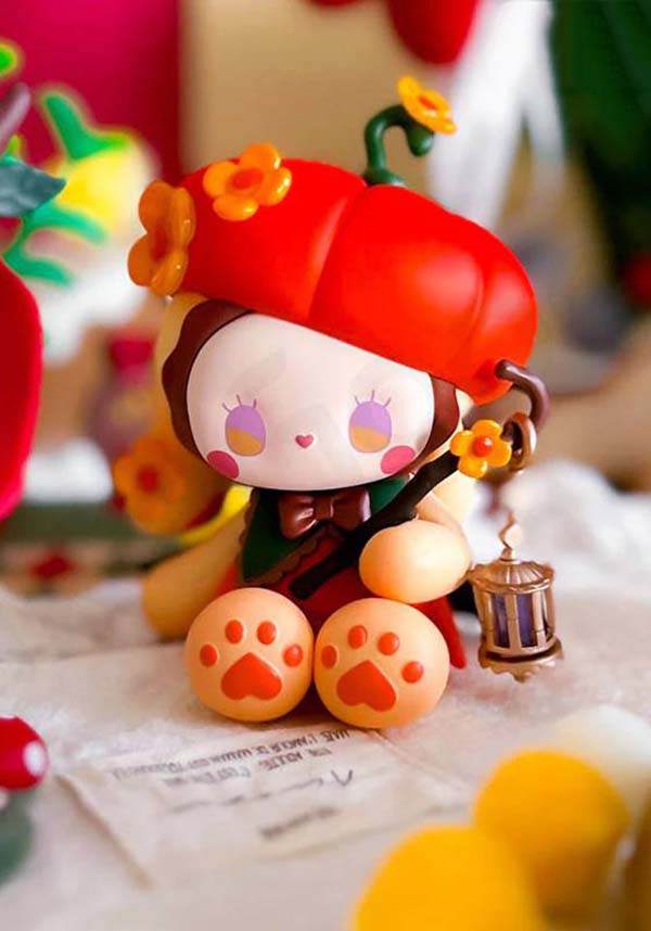 Cute cartoon character figurine with red hat and paw prints on a colorful background