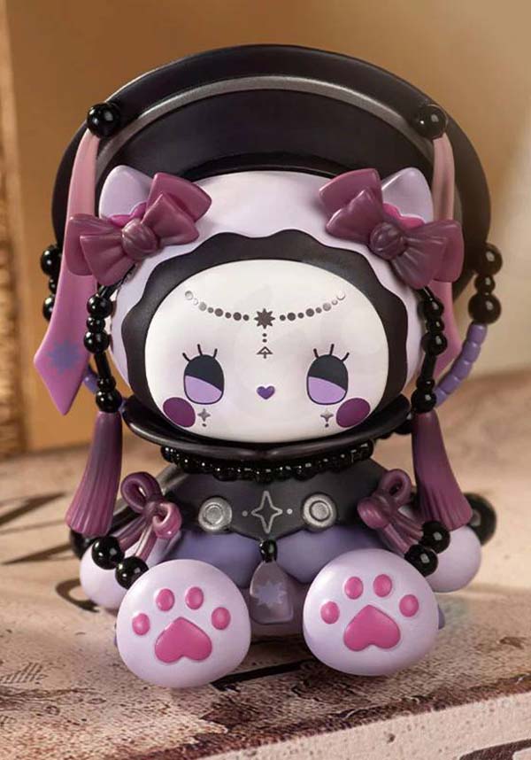 Kawaii-style plush toy with cat ears and pink paw prints on a wooden surface.