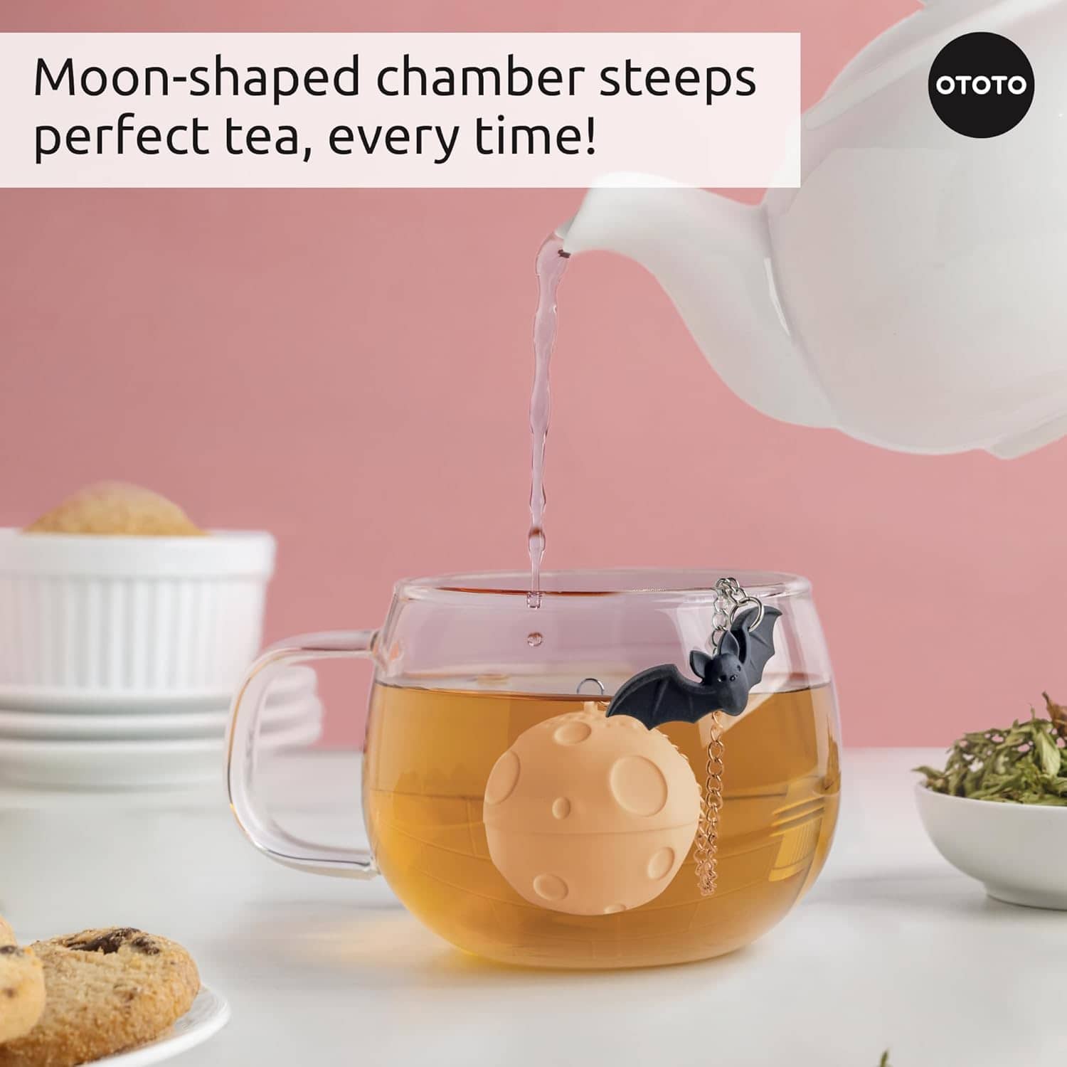 Ototo Moonlit Tea Infuser - In use steeping in glass mug with teapot being poured, pink background
