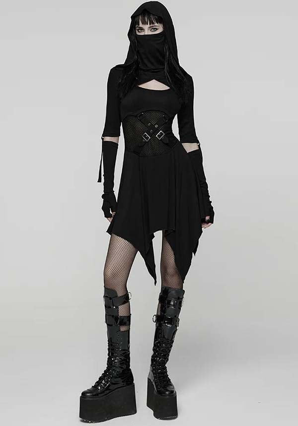 Person wearing a black gothic outfit with a hood and platform boots on a white background