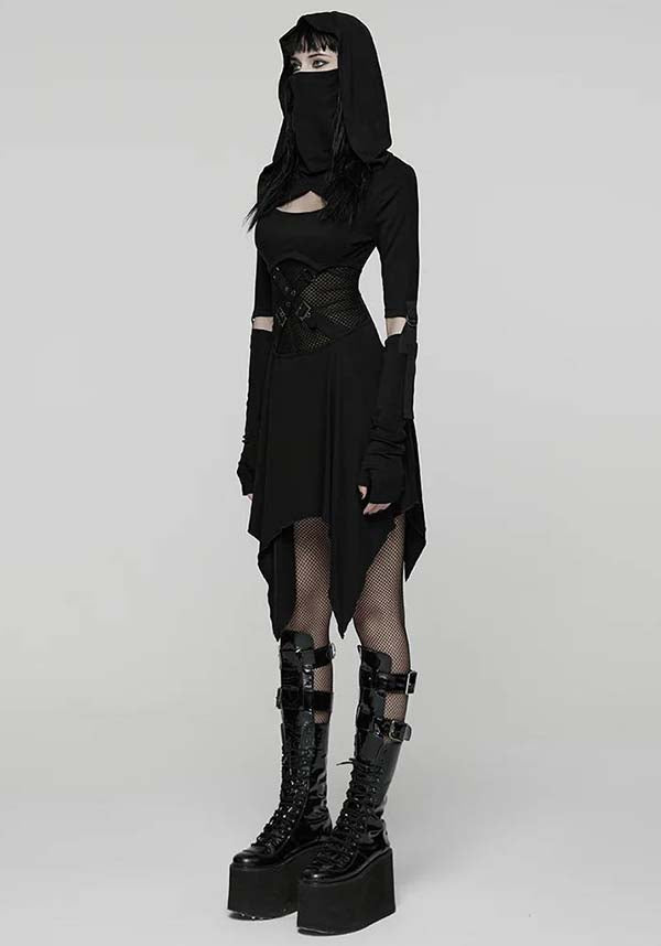 Person wearing a black gothic outfit with a hood and platform boots on a white background